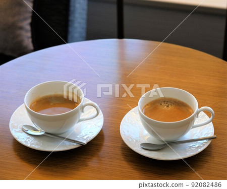 Two coffees placed on a round coffee table Two coffees placed on a round coffee table 92082486