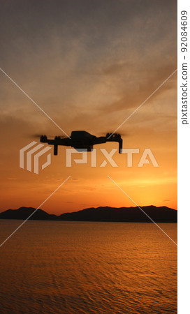 The future and life of drones! SDGs The brilliance of the earth and the brilliant orange sky Vertical photo 92084609