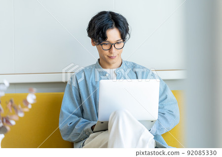 A young man who operates a computer 92085330