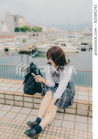 Schoolgirl in uniform and beautiful coastal scenery Schoolgirl in uniform and beautiful coastal scenery 92086242
