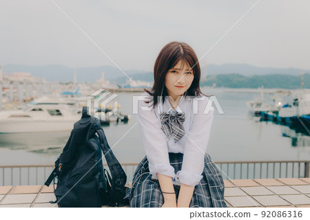 制服和美麗的沿海風景的女學生 制服和美麗的沿海風景的女學生 92086316