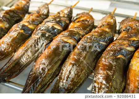 Top view of grilled catfish on charcoal stove. Top view of grilled catfish on charcoal stove. 92086431