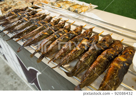 Top view of grilled catfish on charcoal stove. Top view of grilled catfish on charcoal stove. 92086432