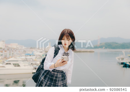 制服和美麗的沿海風景的女學生 制服和美麗的沿海風景的女學生 92086541