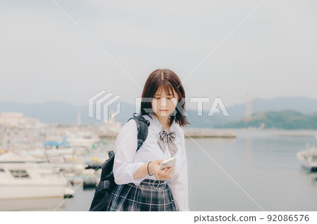 制服和美麗的沿海風景的女學生 制服和美麗的沿海風景的女學生 92086576