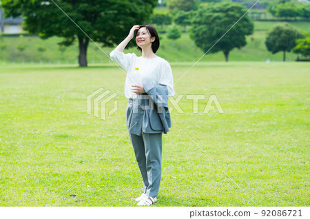Woman in a business suit drinking water outdoors Woman in a business suit drinking water outdoors 92086721