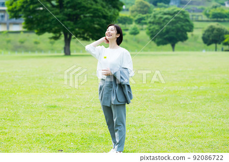 Woman in a business suit drinking water outdoors 92086722