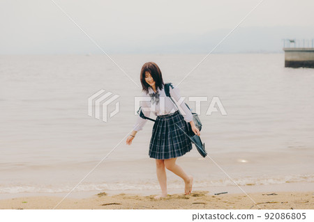 Schoolgirl in uniform and beautiful coastal scenery Schoolgirl in uniform and beautiful coastal scenery 92086805