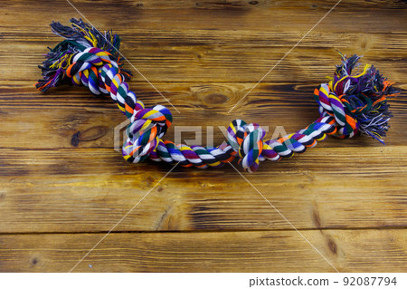 Colorful rope toy for dog on wooden background Colorful rope toy for dog on wooden background 92087794
