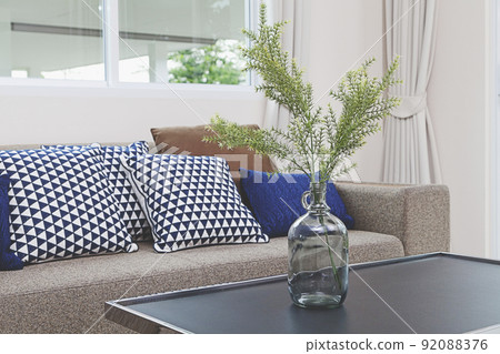 Blue glass vase with tree branches on table in living room. Blue glass vase with tree branches on table in living room. 92088376