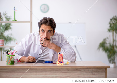 Young male dentist working in the clinic 92088906