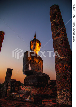 Sunset at Wat Mahathat buddha and temple in Sukhothai Historical Park 92088992