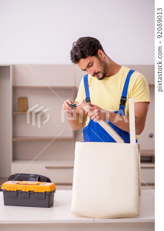Young male carpenter repairing chair at home Young male carpenter repairing chair at home 92089013
