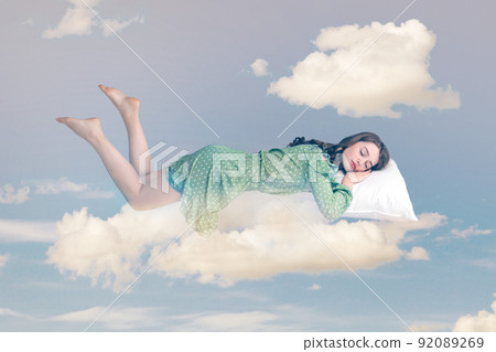 Relaxed girl in ruffle dress levitating in mid-air, sleeping on stomach lying comfortable cozy on pillow, keeping eyes closed, watching peaceful dream. collage composition on day cloudy blue sky 92089269