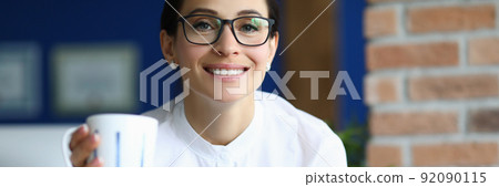 Attractive brunette businesswoman at work with cup of coffee read report Attractive brunette businesswoman at work with cup of coffee read report 92090115