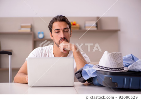 Young man preparing for trip at home Young man preparing for trip at home 92090529