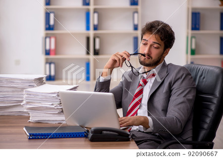 Young male employee unhappy with excessive work in the office 92090667