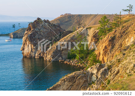 the rocky coast of Olkhon Island on a summer evening at sunset. the blue water of Lake Baikal. the rocky coast of Olkhon Island on a summer evening at sunset. the blue water of Lake Baikal. 92091612