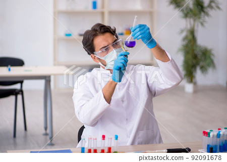 Young male chemist working at the lab 92091678