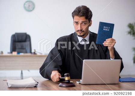 Young male judge taking oath on holly bible 92092198