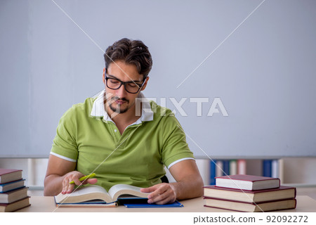 Young male student preparing for exams in the classroom Young male student preparing for exams in the classroom 92092272