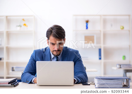 Young male employee working in the office Young male employee working in the office 92093344