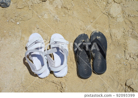 Summer beach Flip-flops left by bathers on the sandy beach Summer beach Flip-flops left by bathers on the sandy beach 92093399