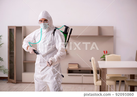 Young male contractor doing pest control at home 92093860