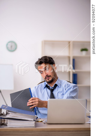 Young male employee working in the office Young male employee working in the office 92094077