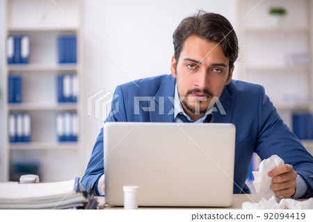 Young male employee suffering at workplace Young male employee suffering at workplace 92094419