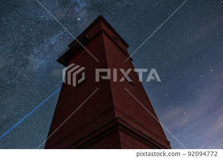 Beautiful night sky behind a shining lighthouse. Starry night and Milky Way 92094772