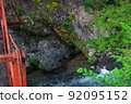A mountain stream with blooming rock azaleas, a red bridge, Nosegawa Village, Nara Prefecture 92095152