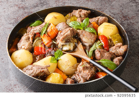 Traditional meat peka with potatoes, carrots, onions, peppers and zucchini and herbs close up. horizontal 92095635