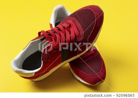 New unbranded running sneaker or trainer on yellow background. Men's sport footwear. 92096865
