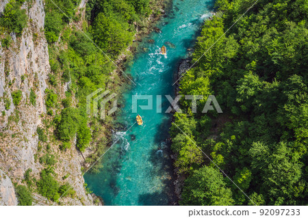 Famous rafting and kayaking place. Active kayakers in colorful life jacket paddling and exercising. Rafting on the turquoise river. Montenegro natural landscape, mountain river Tara 92097233
