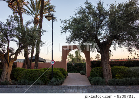 Moroccan city Marrakech Uno cityscape Red-brown wall gate surrounded by palm trees and greenery Moroccan city Marrakech Uno cityscape Red-brown wall gate surrounded by palm trees and greenery 92097813