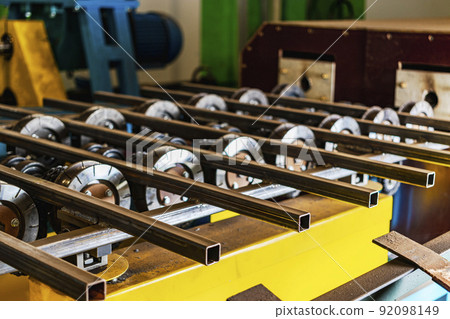 Rolls of an industrial machine for cutting metal. Conveyor line in a factory for processing sheet steel. Close-up of production equipment. Rolls of an industrial machine for cutting metal. Conveyor line in a factory for processing sheet steel. Close-up of production equipment. 92098149