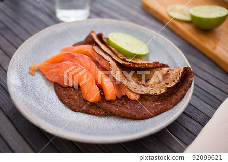 salted salmon fillet with buckwheat pancakes and lime 92099621