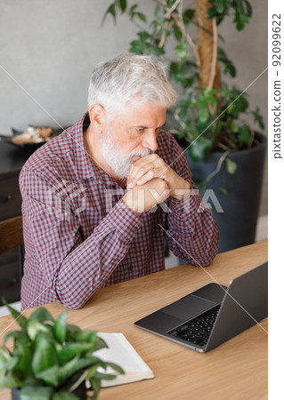 adult business man with gray hair is working at a laptop in his office. career finance and marketing, senior executive lawyer or financier in the company 92099622