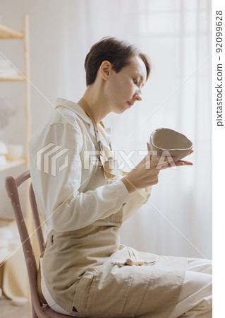 woman ceramist in the workshop makes mugs out of clay. small business or hobby is the creation of ceramic products 92099628