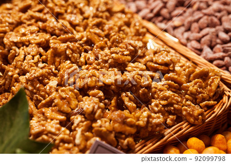 sweet walnut kernels in caramel glaze on counter in market sweet walnut kernels in caramel glaze on counter in market 92099798