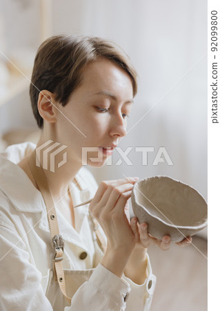 woman ceramist in the workshop makes mugs out of clay. small business or hobby is the creation of ceramic products 92099800