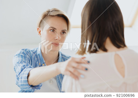 a young and beautiful European woman psychologist or psychiatrist with short blonde hair conducts therapy with a client 92100696