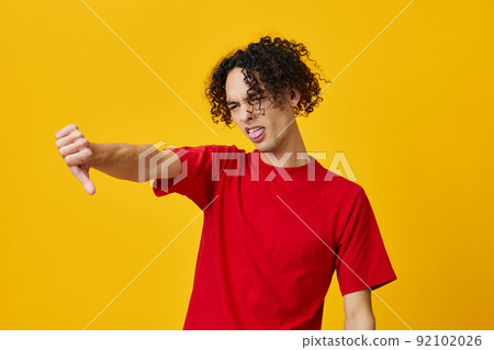 Dissatisfied funny Caucasian young man in red t-shirt show Dis Like gesture posing isolated on yellow studio background. The best offer with free place for advertising. Emotions for everyday concept Dissatisfied funny Caucasian young man in red t-shirt show Dis Like gesture posing isolated on yellow studio background. The best offer with free place for advertising. Emotions for everyday concept 92102026