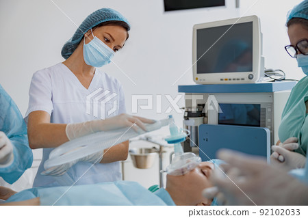 Well-trained anesthesiologist follows the patient during the surgery in clinic Well-trained anesthesiologist follows the patient during the surgery in clinic 92102033