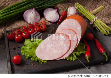 chicken ham on a wooden board decorated with fresh vegetables chicken ham on a wooden board decorated with fresh vegetables 92103041