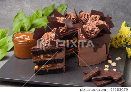 Juicy chocolate sponge cake soaked in dark chocolate cream cheese and peanut paste, with caramel and roasted peanuts filling Juicy chocolate sponge cake soaked in dark chocolate cream cheese and peanut paste, with caramel and roasted peanuts filling 92103079