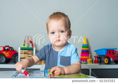 Toddler boy draws with felt-tip pen, developing games for preschoolers.. Toddler boy draws with felt-tip pen, developing games for preschoolers.. 92103581