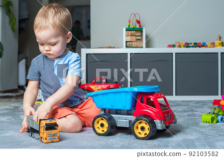 Toddler boy plays in playroom with educational toys... Toddler boy plays in playroom with educational toys... 92103582