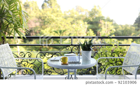 Side view of laptop and yellow coffee cup on glass table Side view of laptop and yellow coffee cup on glass table 92103906